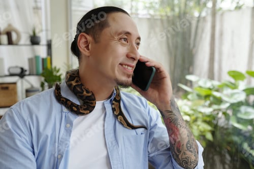 Preview: Smiling Man with Snake on Shoulder During Call