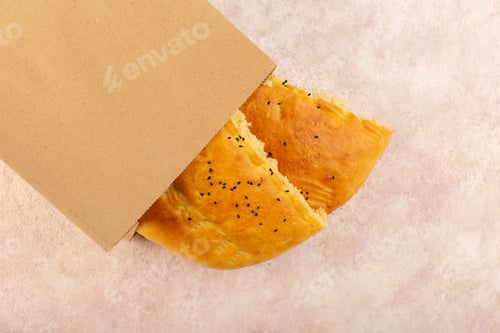 Preview: a top view baked bread hot tasty fresh half sliced inside and outside paper packages on the pink