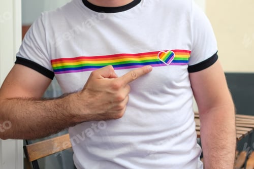 Preview: Man in the T shirt with LGBT flag shows on the heart . Gay and lesbian rights concept