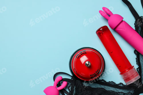 Preview: Lubricant with vibrator, sex bell and black bra on blue background, place for text
