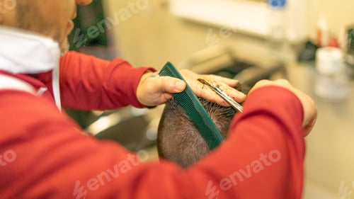Preview: Closeup shot of a Caucasian barber cutting his client's hair.