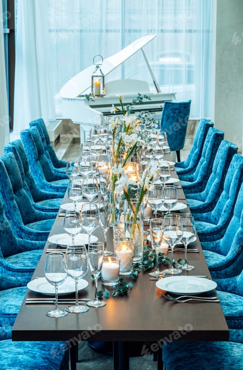 Preview: Table setting. On the banquet table there are plates with napkins and name cards, glasses and cutler