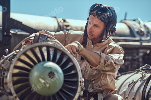 Preview: Mechanic in uniform repairing the dismantled airplane turbine in an open-air museum.