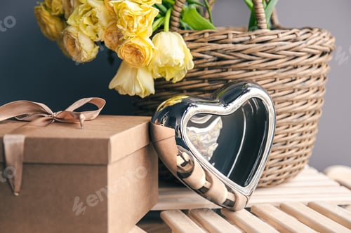 Preview: Festive background with a basket of flowers, a gift box and a heart.