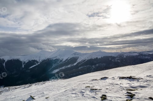 Preview: Winter mountain landscape. Wide view of distant woody mountain peaks