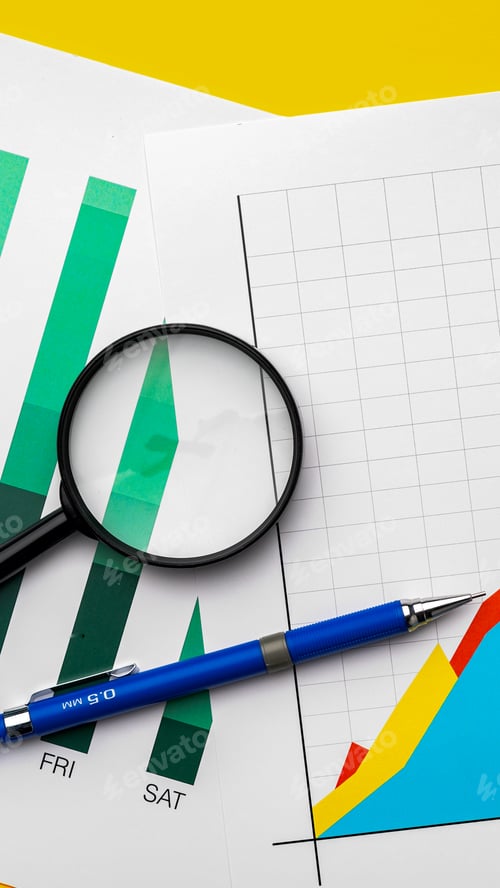 Preview: Graphs and charts with a magnifying glass and pen on a yellow background in an office setting