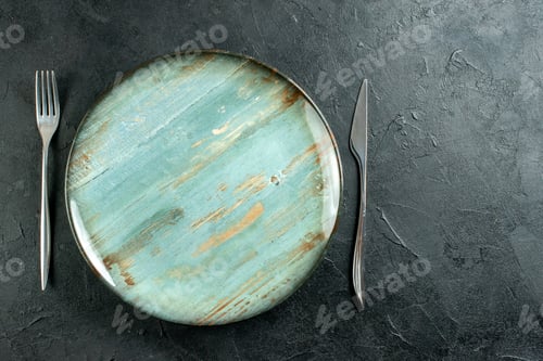 Preview: top view cyan round plate fork and knife on dark background copy place
