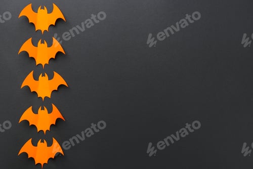 Preview: Halloween decor. Orange paper bats on black background, flat lay. Space for text