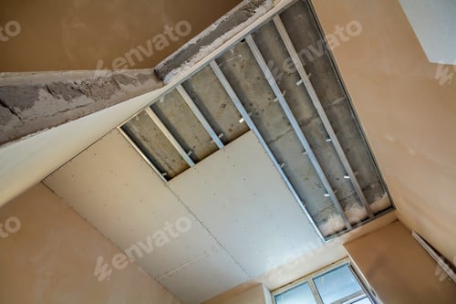 Preview: Angled view of light empty room under construction. Suspended ceiling and walls from drywall fixed