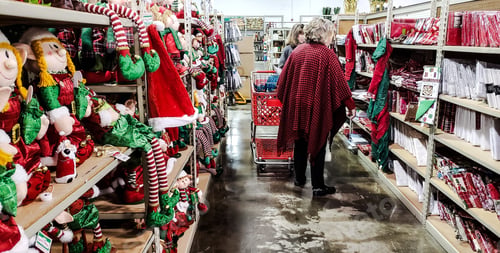 Preview: Holiday shopping in bright and colorful small retail store from behind at Christmas.