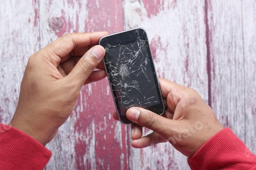 Preview: Close up of man hand holding broken smart phone.