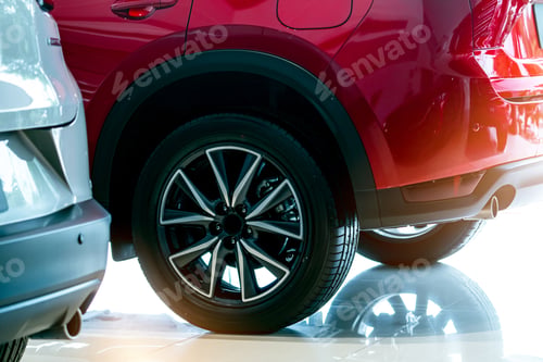 Preview: Closeup wheel of red car parked in showroom. Wheel and tire of new car. Car dealership business