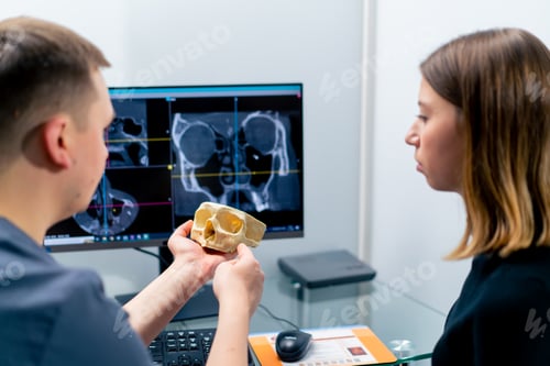 Preview: the radiologist doctor looks at the screen on which the 3D image of the nose scan shows the patient
