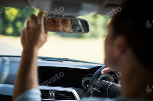 Preview: Man adjusting mirror in car