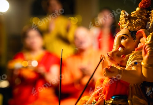 Preview: Indian family offering aarti to Ganpati idol at home with festive decor and traditional wear