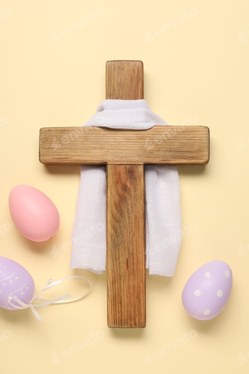 Preview: Wooden cross, white cloth and painted Easter eggs on beige background, flat lay