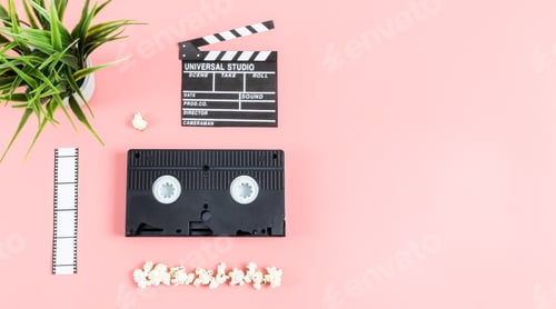 Preview: Cinema clapperboard, film strip, videotape, popcorn and flowerpot on the left against a pink