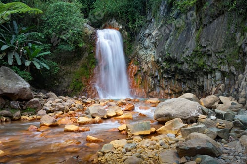 Preview: Red Rocks waterfall cascading over a rugged landscape of rocks in Negros Oriental, Philippines