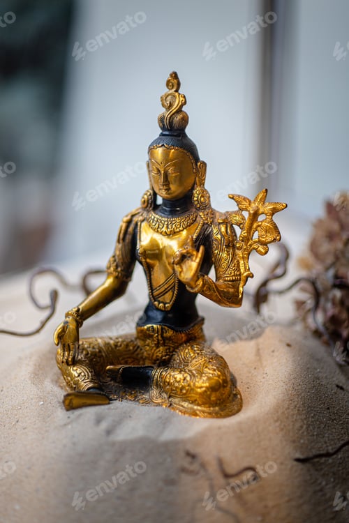 Preview: Seated golden female buddha statue on sand