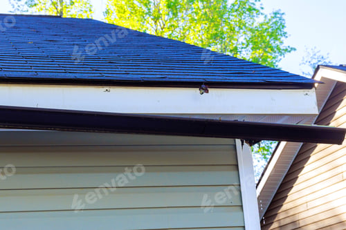 Preview: Broken rain gutter on roof of a house after hurricane damages