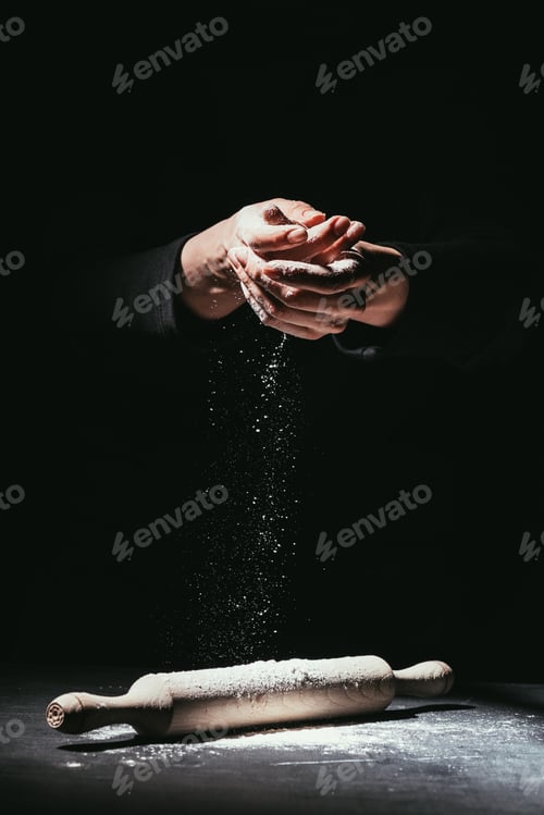 Preview: cropped shot of chef with hands covered in flour and rolling pin on table