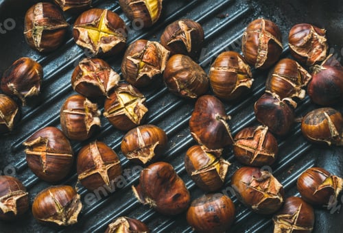 Preview: Roasted chestnuts over black cast iron grilling pan surface