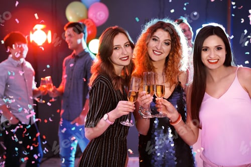 Preview: Young women chinking glasses in nightclub. Birthday party