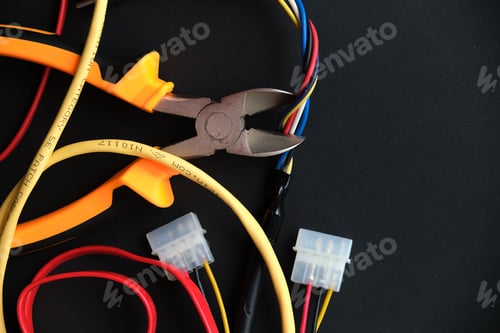 Vista previa: Pliers tool cutting red electric wire closeup on black background, service and repairing concept