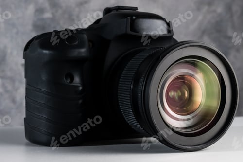 Preview: Black digital camera on a table with grunge background.