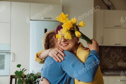 Visualização: Filha abraçando e presenteando flores para a mãe no Dia das Mães