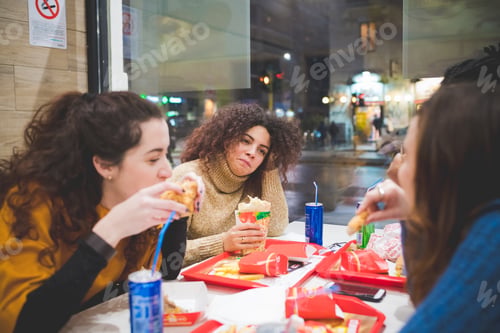 Preview: group of young girlfriends having dinner in fast food