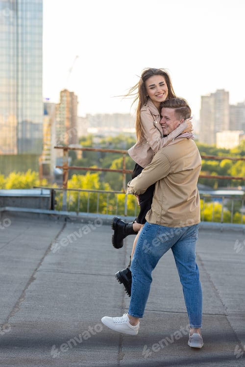 Preview: Beautiful happy young loving couple on a surprise date on a Saint Valentine's Day on a rooftop