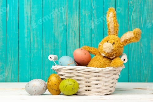 Preview: Bunny with colorful eggs in a basket on a wooden table