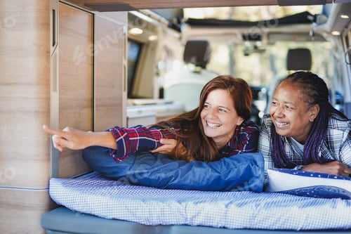 Preview: Mature multiracial women relax inside mini van camper