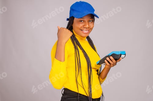 Preview: African lady smiling and holding a payment terminal - the concept of sales