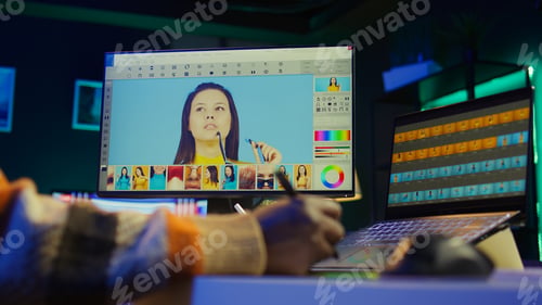 Preview: Male graphic artist using essential digital tools on dual monitors