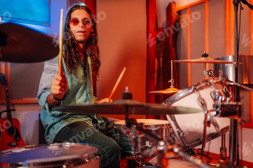 Preview: Drummer performing on a white drum set in a music studio.