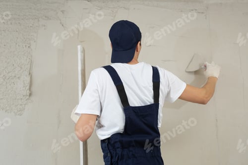 Preview: A hand with a spatula. Workers put putty on the wall with a spatula. Aligns wall.