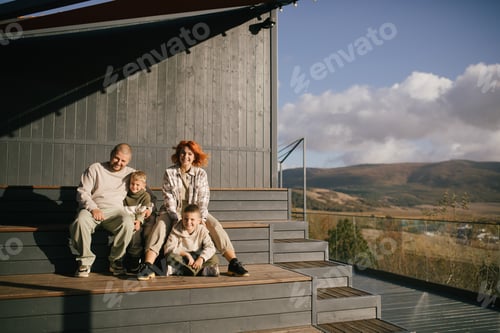Preview: Happy family of father, mother and two sons spending time together outdoors.