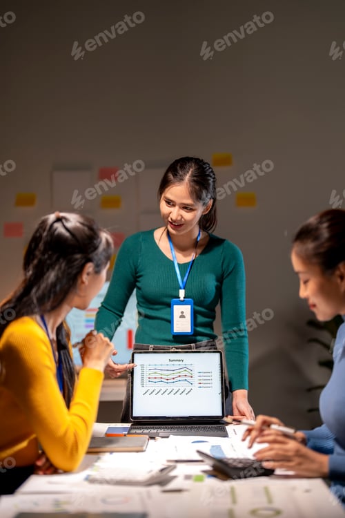 Preview: Three women are sitting at a table with a laptop open in front of them