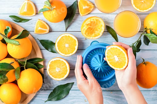 Preview: Woman squeezing orange juice from fresh oranges