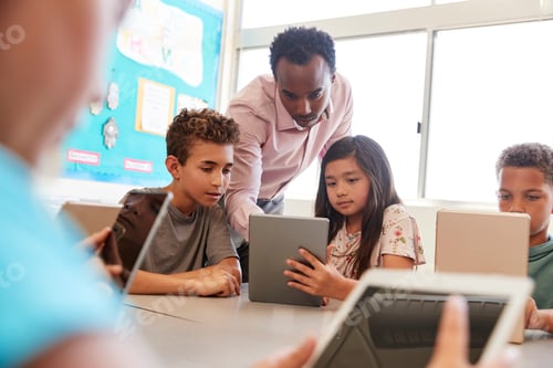 Preview: Teacher among school kids using computers in class
