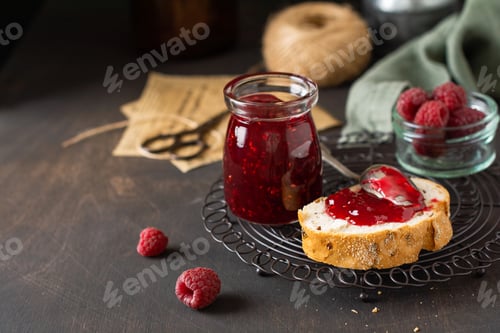 Preview: Raspberry jam in glass jar and sandwich with fresh raspberry berries on the old retro background. Se