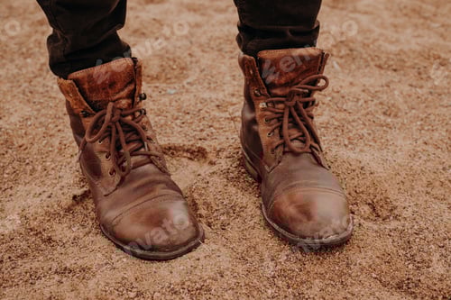 Preview: Image of unrecognizable man stands on sandy ground in brown leather old shaggy shoes