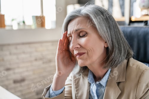 Preview: Stressed unhealthy businesswoman massaging temples, suffering from headache or high blood pressure