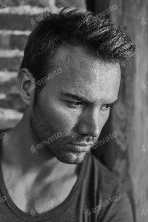 Preview: Pensive Handsome Man Lying on a Brick Wall