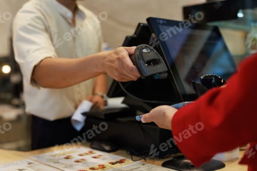 Preview: Employee scanning product for customer at retail counter