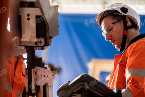 Preview: A team of male engineers meeting to inspect computer-controlled steel welding robots