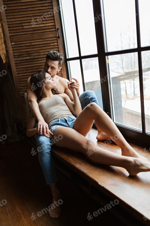 Preview: Loving Couple Embracing near the Window at Home