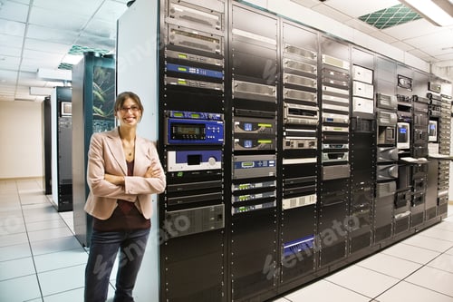 Preview: Portrait of female technician working in a large computer server room.